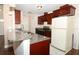 Open kitchen with granite countertops, stainless steel appliances, and white tiled floors at 1090 Parnell Ct, Deltona, FL 32738