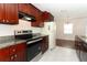Updated kitchen with stainless steel oven and featuring granite countertops and dark wood cabinets at 1090 Parnell Ct, Deltona, FL 32738