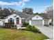 Charming single-story home with well-manicured landscaping, three car garage and a beautiful orange front door at 10987 Piping Rock Cir, Orlando, FL 32817