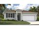 Charming single-story home with a two-car garage, gray exterior, and well-maintained lawn at 1128 Clay Blvd, Tavares, FL 32778