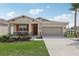 Inviting single-Gathering home with a front porch, colorful shutters, and a two-car garage at 1128 Clay Blvd, Tavares, FL 32778