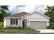 Charming single-story home with a two-car garage, stone accents, and beautifully landscaped front yard at 1130 Clay Blvd, Tavares, FL 32778