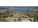 Panoramic aerial showcasing a large lake next to wooded areas, fields, and a few buildings at 1262 Stonewater Cir, Ocoee, FL 34761