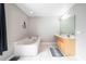 Bright bathroom with a soaking tub, vanity, and decorative mirror with light tile floors at 1262 Stonewater Cir, Ocoee, FL 34761
