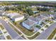 Aerial view of two-story homes in a residential community surrounded by lush green trees and a pond at 178 Marcello Blvd, Kissimmee, FL 34746