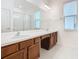 Bathroom featuring a double vanity, large mirror, window, and glass-enclosed shower at 178 Marcello Blvd, Kissimmee, FL 34746