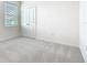 Carpeted bedroom with a large window, double doors, and neutral walls at 178 Marcello Blvd, Kissimmee, FL 34746