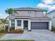 Beautiful two-story home featuring a gray stucco exterior, attached garage, and well-manicured landscaping at 178 Marcello Blvd, Kissimmee, FL 34746