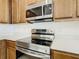 Stainless steel stove with overhead microwave and white quartz countertops and cabinets offer a modern kitchen experience at 178 Marcello Blvd, Kissimmee, FL 34746