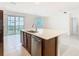 Modern kitchen island with stainless steel appliances, sink, tile floors and a sliding door leading to the back yard at 178 Marcello Blvd, Kissimmee, FL 34746