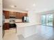 Open kitchen with a large island, stainless appliances, tile floors, and sliding doors with a view of the backyard at 178 Marcello Blvd, Kissimmee, FL 34746