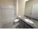 A bathroom features a granite countertop, white vanity, white tiled shower and tub at 2877 Sunridge Loop, St Cloud, FL 34771