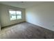 A carpeted bedroom features a window with views of the exterior pond and community at 2877 Sunridge Loop, St Cloud, FL 34771