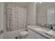 Cozy bathroom with shower-tub combo, white vanity, and neutral walls and decorative shower curtain at 2916 Satire St, Kissimmee, FL 34746