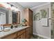 Bathroom featuring a vanity with granite counters and updated mirror with a storage cabinet at 2929 Lakeshore Dr, Mount Dora, FL 32757