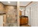 This bathroom showcases a walk-in shower with stone-look tiles, contrasted by wood cabinets at 2929 Lakeshore Dr, Mount Dora, FL 32757