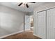 Carpeted bedroom with a ceiling fan and closet, showcasing an open doorway to another room at 2929 Lakeshore Dr, Mount Dora, FL 32757