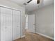 Carpeted bedroom with a ceiling fan and a double door closet at 2929 Lakeshore Dr, Mount Dora, FL 32757