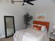 Cozy bedroom with soft lighting, orange accents, and plush bedding, offering a serene retreat at 2929 Lakeshore Dr, Mount Dora, FL 32757