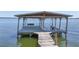 Beautiful boat dock featuring a covered area, swing and bench at 2929 Lakeshore Dr, Mount Dora, FL 32757