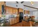 Kitchen featuring wood cabinets, black appliances, granite countertops, a spacious island, and hardwood floors at 2929 Lakeshore Dr, Mount Dora, FL 32757