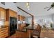 Kitchen showcasing wood cabinets, black appliances, a center island, and hardwood floors leading to the living area at 2929 Lakeshore Dr, Mount Dora, FL 32757