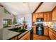 Modern kitchen featuring an eat-in island, wood cabinets, granite countertops, and black appliances at 2929 Lakeshore Dr, Mount Dora, FL 32757