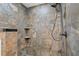 Walk-in shower showcases decorative stone tile, black fixtures, and convenient shelving at 2929 Lakeshore Dr, Mount Dora, FL 32757