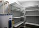 Storage room equipped with multiple shelves and a water heater at 2929 Lakeshore Dr, Mount Dora, FL 32757