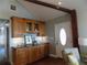 Home wet bar featuring stylish wooden cabinets with glass doors and granite countertop for entertaining at 2929 Lakeshore Dr, Mount Dora, FL 32757