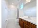 Bright bathroom featuring a shower-tub combo, wooden vanity with white countertop, and a light gray tile floor at 299 Marcello Blvd, Kissimmee, FL 34746