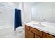 Bright bathroom features a shower-tub combo with modern fixtures and a wood vanity with solid surface counter at 299 Marcello Blvd, Kissimmee, FL 34746
