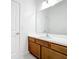 Bathroom vanity with wood cabinets, white countertop, sink and large mirror at 299 Marcello Blvd, Kissimmee, FL 34746