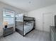 Comfortable bedroom featuring a gray bunk bed set, bedside table, and dresser at 299 Marcello Blvd, Kissimmee, FL 34746