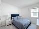 Bright bedroom features a soft bed with nightstands, complemented by plush carpeting, and freshly painted white walls at 299 Marcello Blvd, Kissimmee, FL 34746