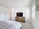 Bright bedroom with a TV, a large window, and a doorway to an adjacent room at 299 Marcello Blvd, Kissimmee, FL 34746
