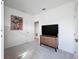 Minimalist bedroom featuring modern furniture, a sleek TV stand, plush carpeting, and freshly painted white walls at 299 Marcello Blvd, Kissimmee, FL 34746