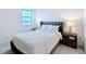 Bedroom features a plush bed with a window view, complemented by stylish nightstands and lamps at 299 Marcello Blvd, Kissimmee, FL 34746