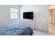Bright bedroom featuring modern furniture, a sleek TV stand, plush carpeting, and freshly painted white walls at 299 Marcello Blvd, Kissimmee, FL 34746