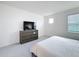 Serene bedroom with sleek furniture, a large dresser and television, offering a tranquil personal space at 299 Marcello Blvd, Kissimmee, FL 34746
