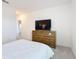 Neutral bedroom features a wooden dresser with drawers and a television at 299 Marcello Blvd, Kissimmee, FL 34746