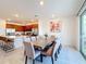 Open-concept dining area with a long wooden table and access to the outdoor patio at 299 Marcello Blvd, Kissimmee, FL 34746