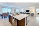 Open-concept kitchen featuring a large island with seating, stainless steel appliances, and view of the living area at 299 Marcello Blvd, Kissimmee, FL 34746
