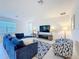 Well-lit living room offers ample seating with a plush blue sectional and patterned accent chair at 299 Marcello Blvd, Kissimmee, FL 34746