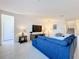 Cozy living room with a blue sofa, TV, and a staircase in the background at 299 Marcello Blvd, Kissimmee, FL 34746