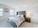 Stylish main bedroom features a tufted headboard, two bedside tables with lamps, and a bright window at 299 Marcello Blvd, Kissimmee, FL 34746