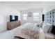 Inviting main bedroom with natural light, a large TV, and a comfortable bed at 299 Marcello Blvd, Kissimmee, FL 34746