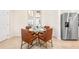 Dining area featuring a glass table and brown leather chairs next to a stainless steel refrigerator at 300 Preston Cove Dr, St Cloud, FL 34771