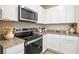 A modern kitchen featuring stainless steel appliances, granite countertops, and white cabinetry at 300 Preston Cove Dr, St Cloud, FL 34771