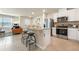 Open kitchen with stainless appliances, white cabinetry, and a breakfast bar, perfect for modern living at 300 Preston Cove Dr, St Cloud, FL 34771